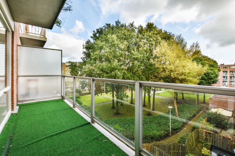 deck with glass railing and synthetic grass floor